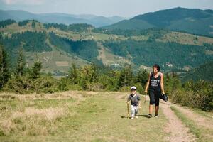 Young mom with baby boy travelling. Mother on hiking adventure with child, family trip in mountains. National Park. Hike with children. Active summer holidays. Fisheye lens. photo