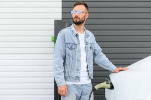 Man standing by his electric car photo