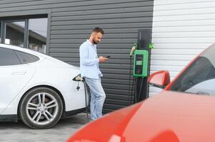 a man charges an electric car photo