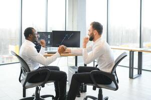 Two happy successful excited diverse traders investors giving high five celebrating successful stock exchange trading deal photo