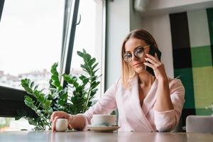 beautiful business lady drinking coffee and uses different gadgets photo