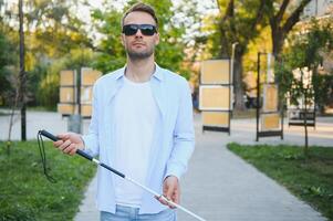 Blind man. Visually impaired man with walking stick, photo