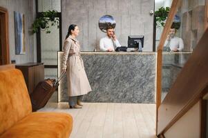 Elegant Business Woman with Travel Trolley Luggage in Hotel Lobby photo