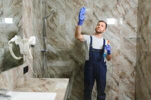 limpieza servicio, un hombre limpia el baño foto