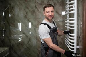 plumber service. handyman installing heating radiator photo