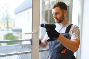 Worker installing plastic window indoors. photo