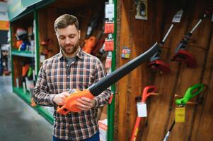 a young man in a gardening equipment store photo