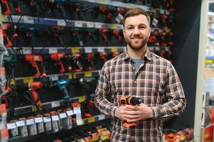 retrato de contento maduro hombre en pie en hardware Tienda foto