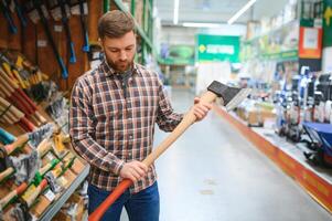 happy customer in a hardware store buying a new ax photo