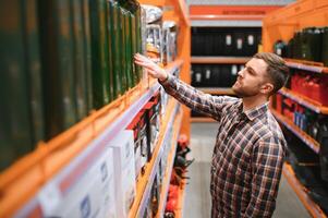 A male customer stands in an auto parts store with a jerry can photo