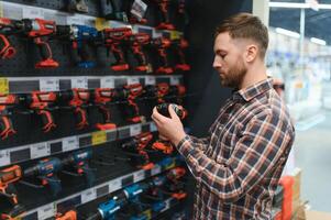 Man shopping for drill in hardware store photo