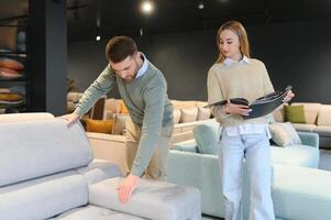 Pareja elegir sofá y almohadas a mueble Tienda foto