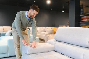 Man in furniture store choosing sofa photo