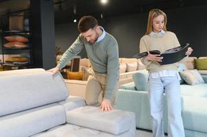 Happy couple choosing furniture in store photo