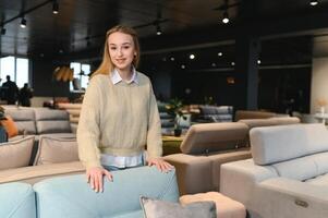 joven mujer compras para muebles, sofá y hogar decoración en Tienda foto