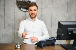 Portrait of receptionist at desk in lobby, hotel photo