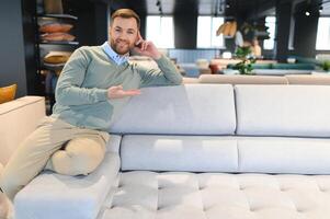 Man in furniture store choosing sofa photo