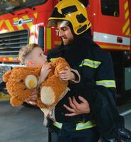 Firefighter holding child boy to save him in fire and smoke,Firemen rescue the boys from fire photo