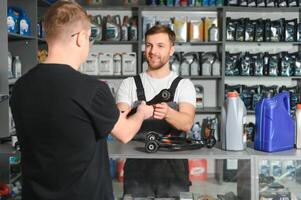 The seller selects new car repair parts for the client photo