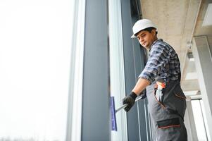 Male janitor cleaning window in office photo