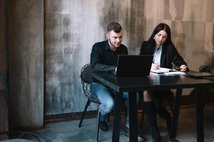 business man and woman working behind laptop photo