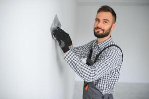 joven trabajador haciendo reparar en habitación. foto