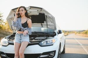 triste mujer Deprimido no conocimiento qué a hacer con roto coche foto