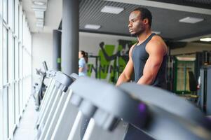 negro africano americano joven hombre haciendo cardio rutina de ejercicio a el gimnasio foto