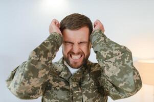 Depressed man recalling war days. Portrait of veteran soldier who has PTSD photo