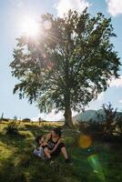 joven mamá con bebé chico de viaje. madre en excursionismo aventuras con niño, familia viaje en montañas. nacional parque. caminata con niños. activo verano vacaciones. ojo de pez lente. foto