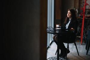 Happy young businesswoman using tablet computer in a cafe. Selective focus photo