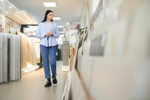 Woman choosing bathroom tile in building market photo