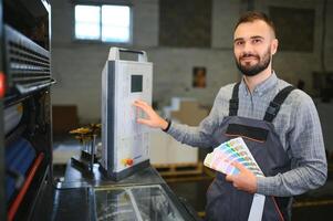 Graphic engineer or worker checking imprint quality in modern print shop photo