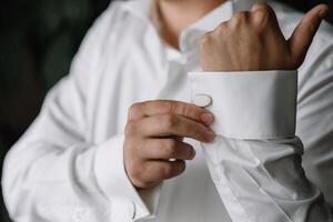 masculino manos en un antecedentes de un blanco camisa, manga camisa con gemelos y relojes, fotografiado de cerca. foto