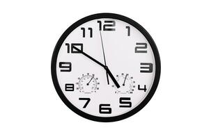 simple classic black and white round wall clock isolated on white. Clock with arabic numerals on wall shows photo