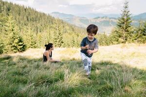 joven mamá con bebé chico de viaje. madre en excursionismo aventuras con niño, familia viaje en montañas. nacional parque. caminata con niños. activo verano vacaciones. ojo de pez lente. foto