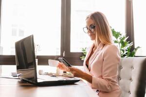 hermosa negocio mujer son sentado a analizar el trabajo plan. negocio niña son estudiando estrategias para desarrollando un márketing plan y aprendizaje a resolver trabajo problemas foto