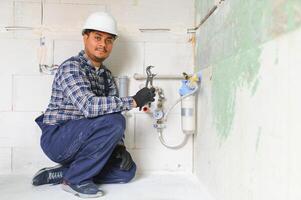 indio fontanero instalando agua equipo - metro, filtrar y presión reductor foto