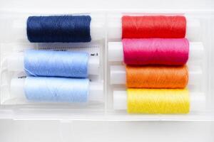 Multicolored skeins of thread in the set. The threads are in a plastic box. photo
