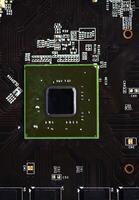 A brown printed circuit board with a processor chip and memory strips. Electronic components on the graphics card. photo