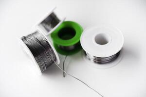 Tin-lead solder in coils on a white background. Materials for soldering. photo