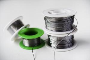 Tin-lead solder in coils on a white background. Materials for soldering. photo