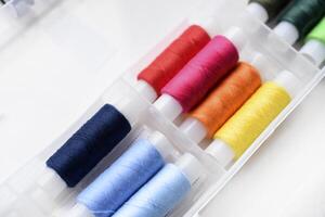 Multicolored skeins of thread in the set. The threads are in a plastic box. photo