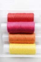 Multicolored skeins of thread in the set. The threads are in a plastic box. photo