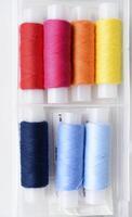 Multicolored skeins of thread in the set. The threads are in a plastic box. photo
