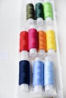 Multicolored skeins of thread in the set. The threads are in a plastic box. photo