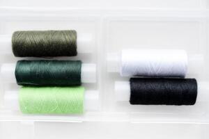 Multicolored skeins of thread in the set. The threads are in a plastic box. photo