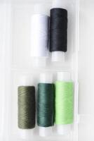 Multicolored skeins of thread in the set. The threads are in a plastic box. photo