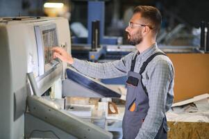 printing house, experimented technician works on UV printer. Production work photo