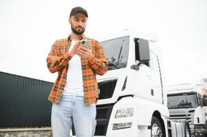 retrato de joven barbado hombre en pie por su camión. profesional camión conductor en pie por semi camión vehículo. foto